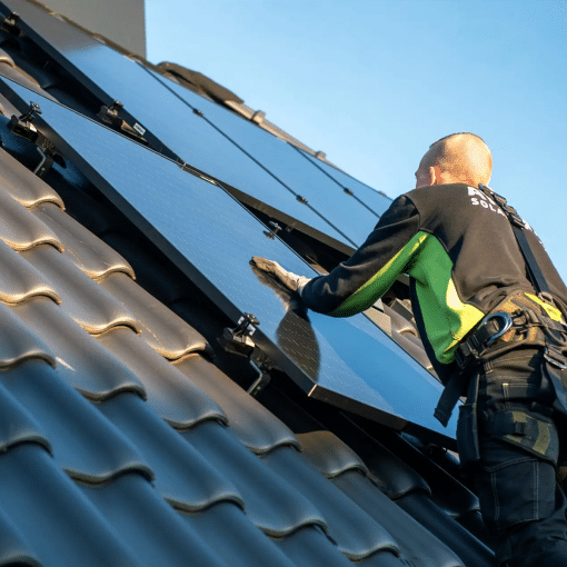 Monteur installeert zonnepanelen op een schuin pannendak met behulp van het ClickFit montagesysteem.